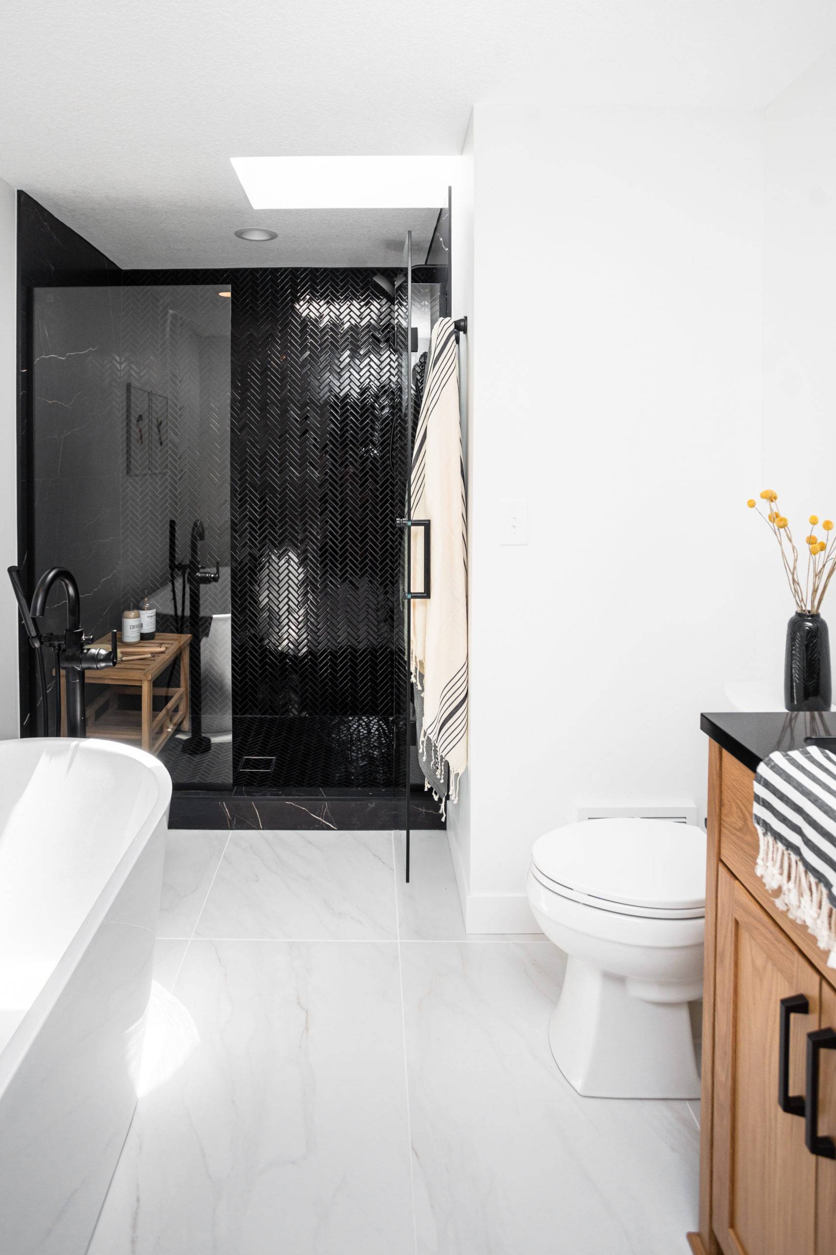 Modern bathroom with white marble flooring and black tiled shower