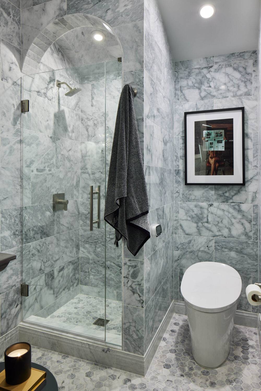 Bathroom with stark-white with grey veining marble walls and grey and white hexagon marble tile floor. 