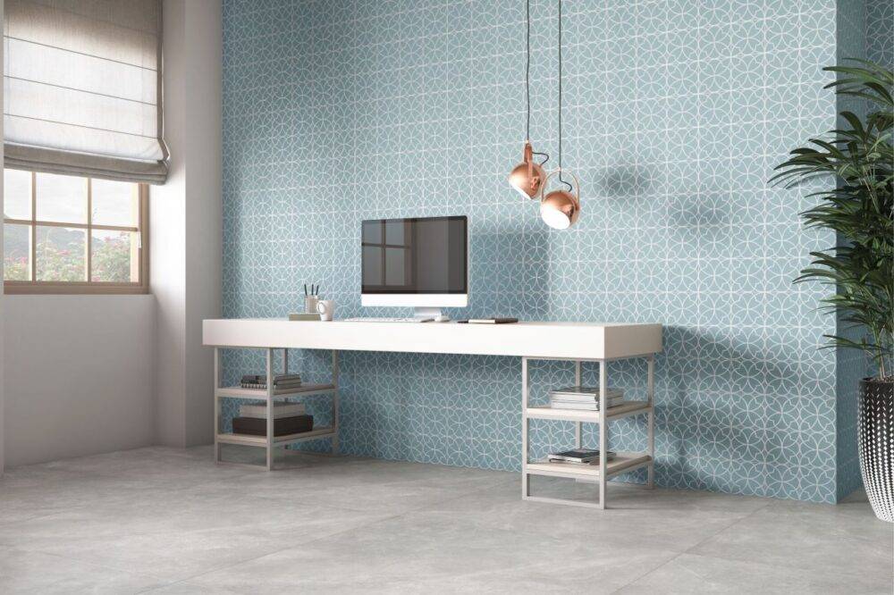 Office wall with blue and white patterned tile and grey tile floor.