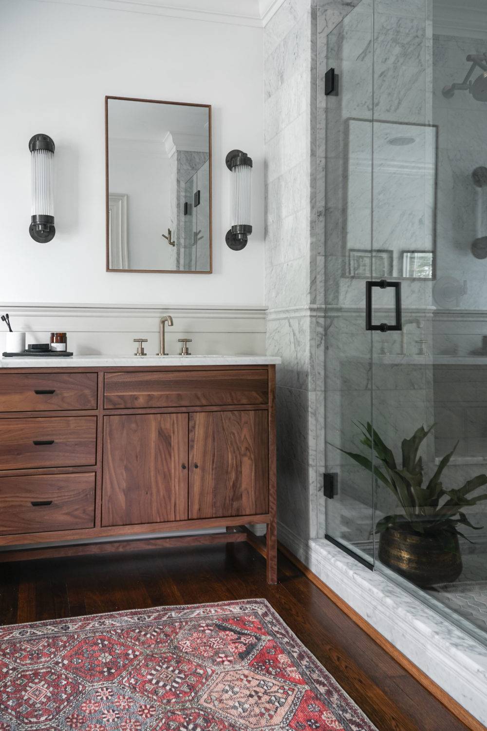 Traditional bathroom with grey marble shower and dark wood vanity 