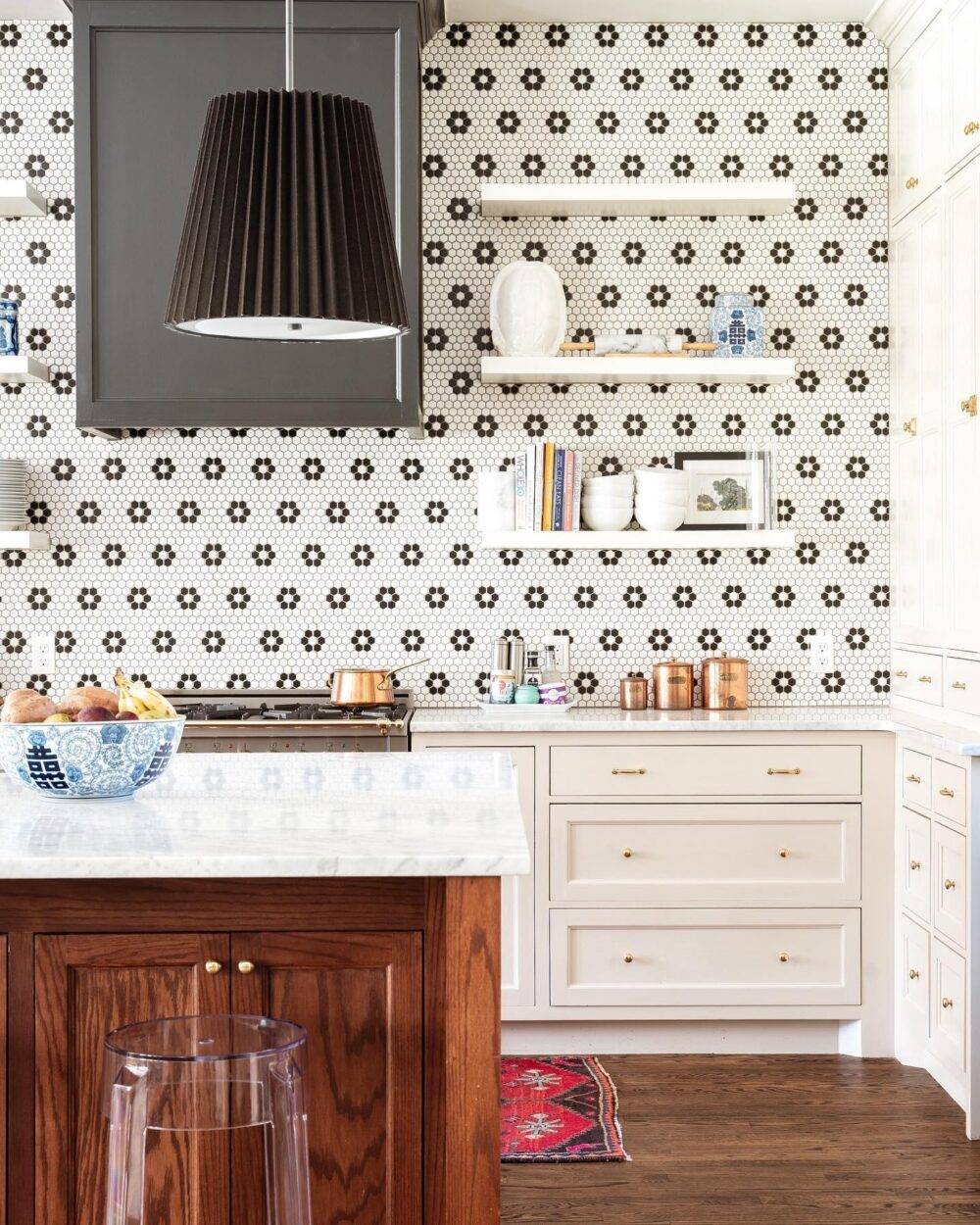 Kitchen with white with black flower-patterned hexagon tile wall. 