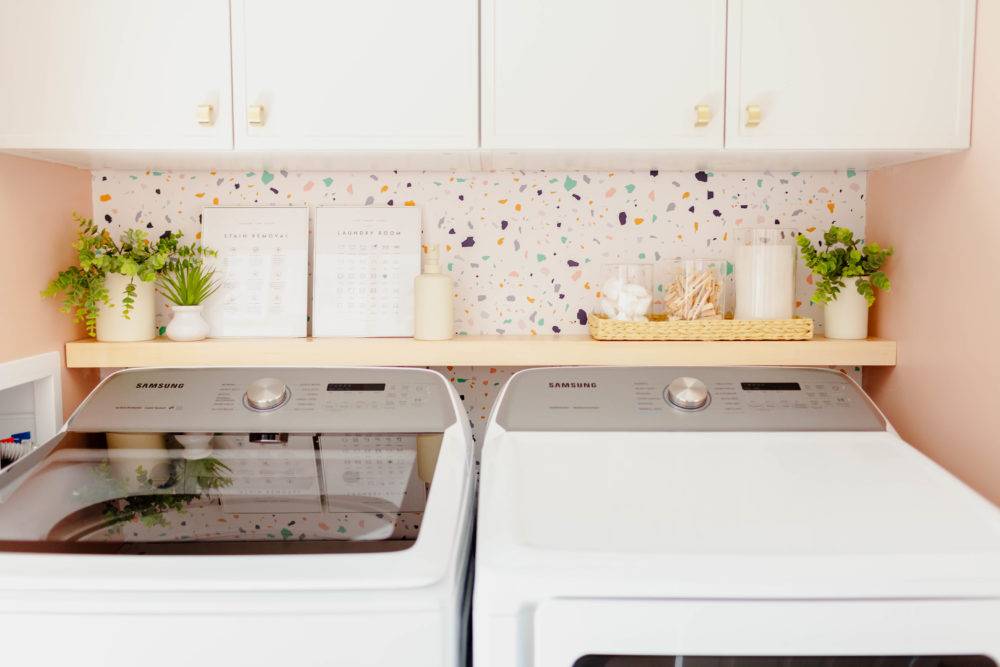 Laundry room washer and dryer with colorful terrazzo patterned wallpaper