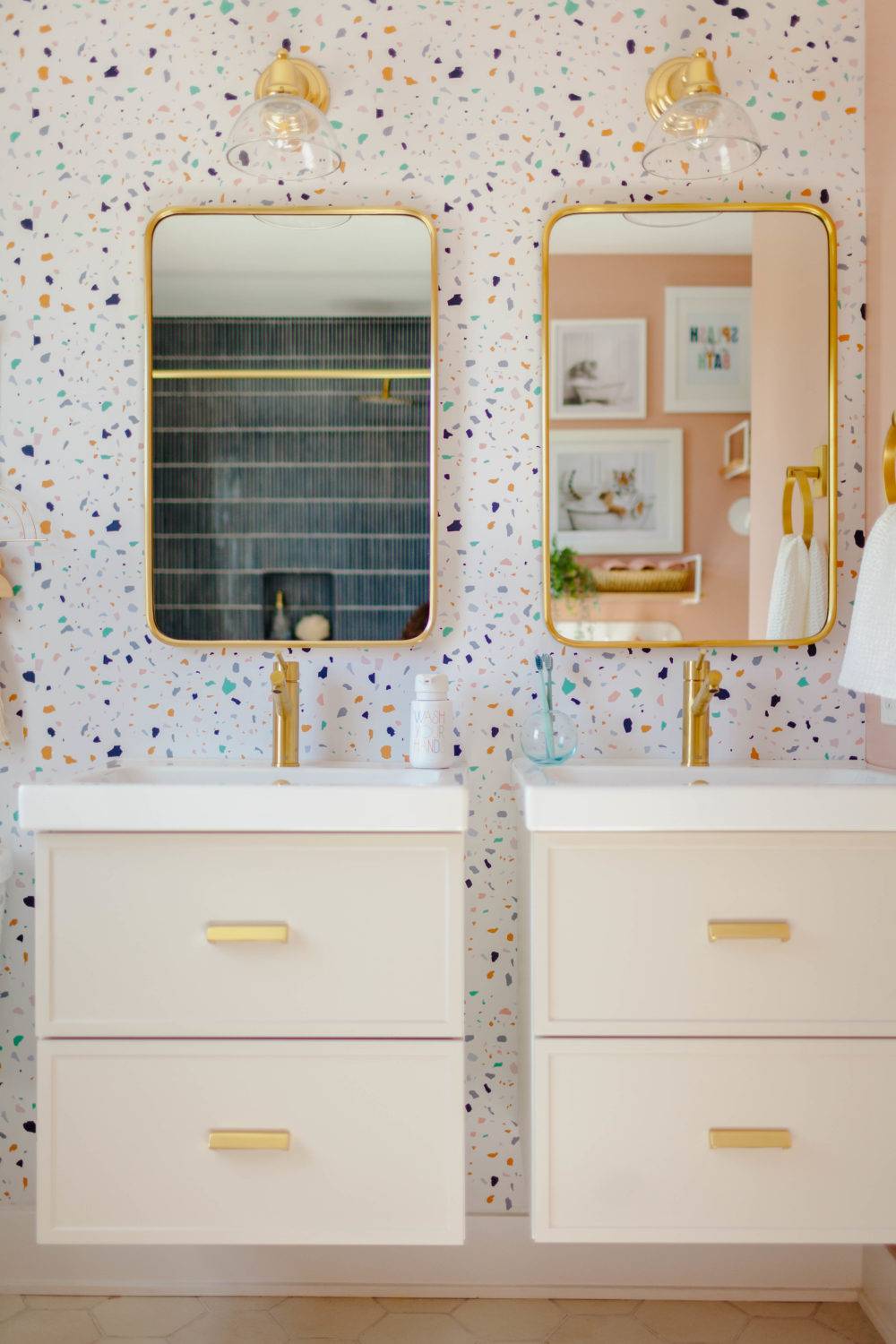 Kids bathroom with pink walls and colorful terrazzo patterned wallpaper