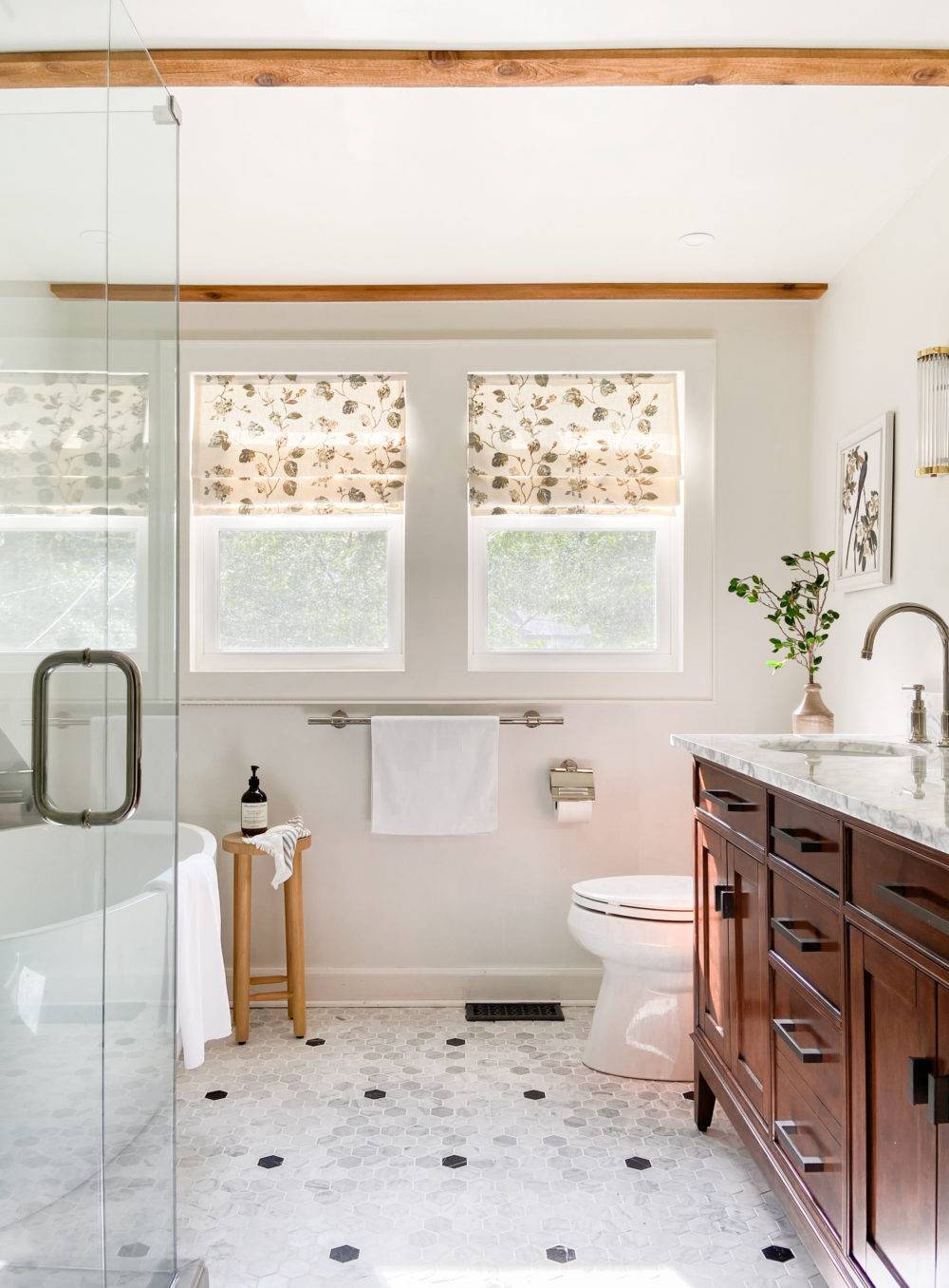 Bright white bathroom with polkadot hex tile flooring and dark wood vanity 