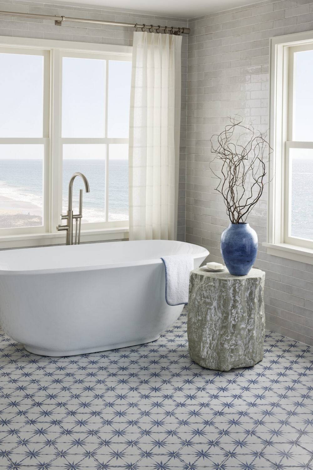 Coastal bathroom with blue and white patterned floor tile. 