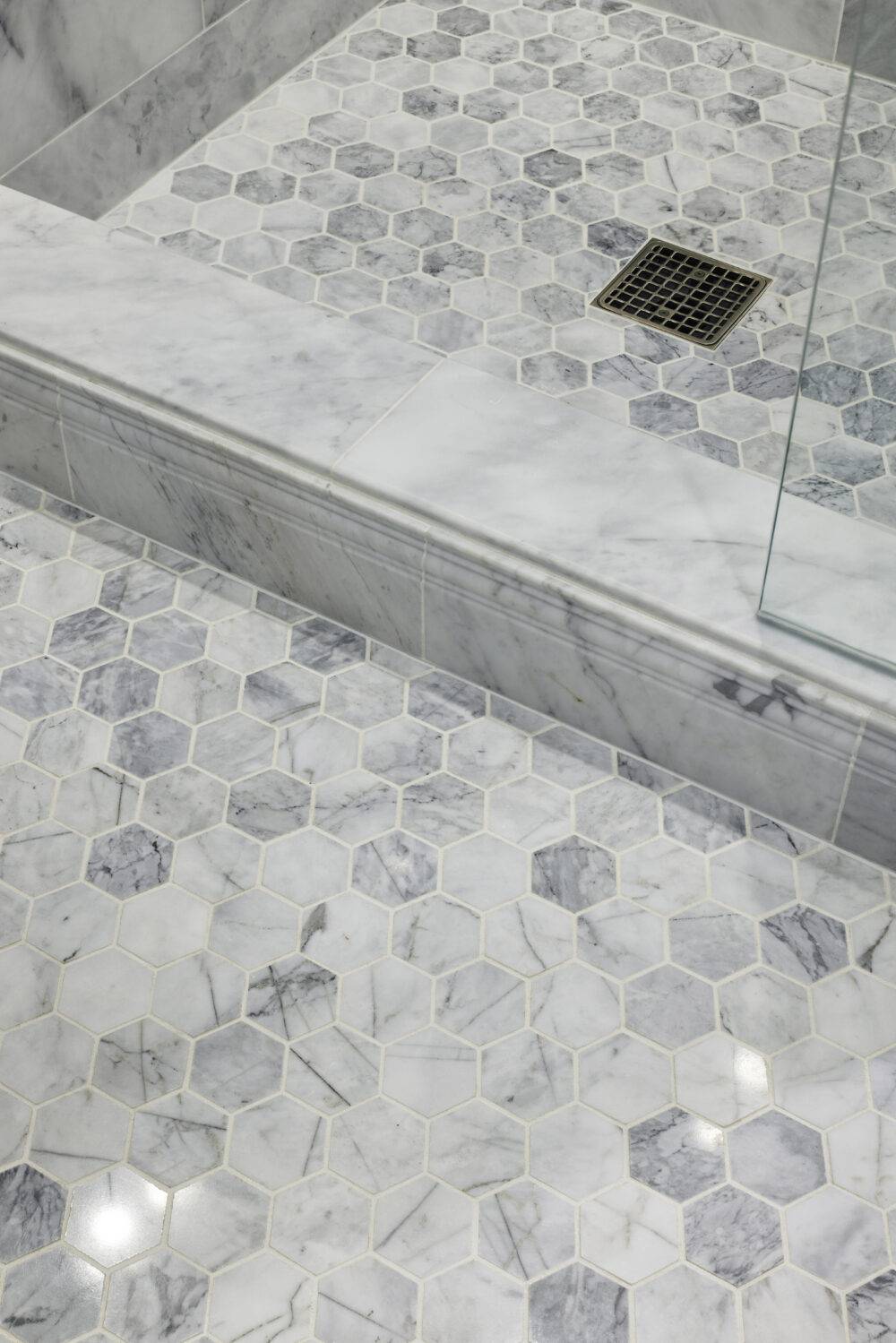 A shower floor featuring grey Ashford Cararra hexagon tile. 