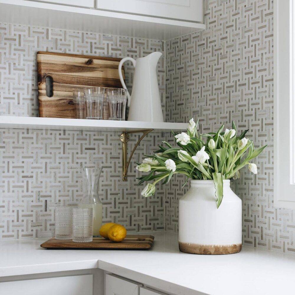 Kitchen counter with marble basket-weave tile wall.
