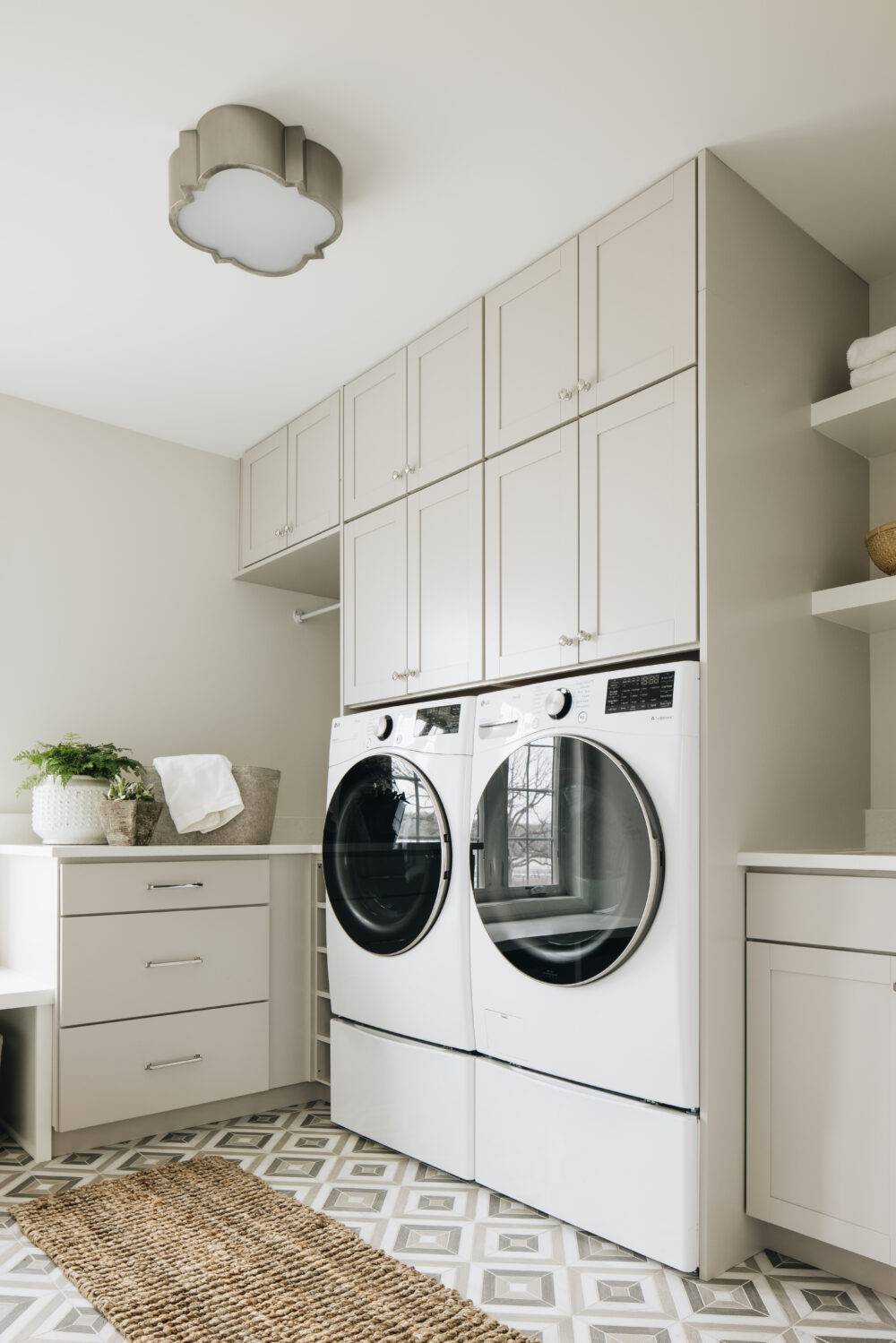 Beige and grey laundry room with grey square-patterned tile floor. 
