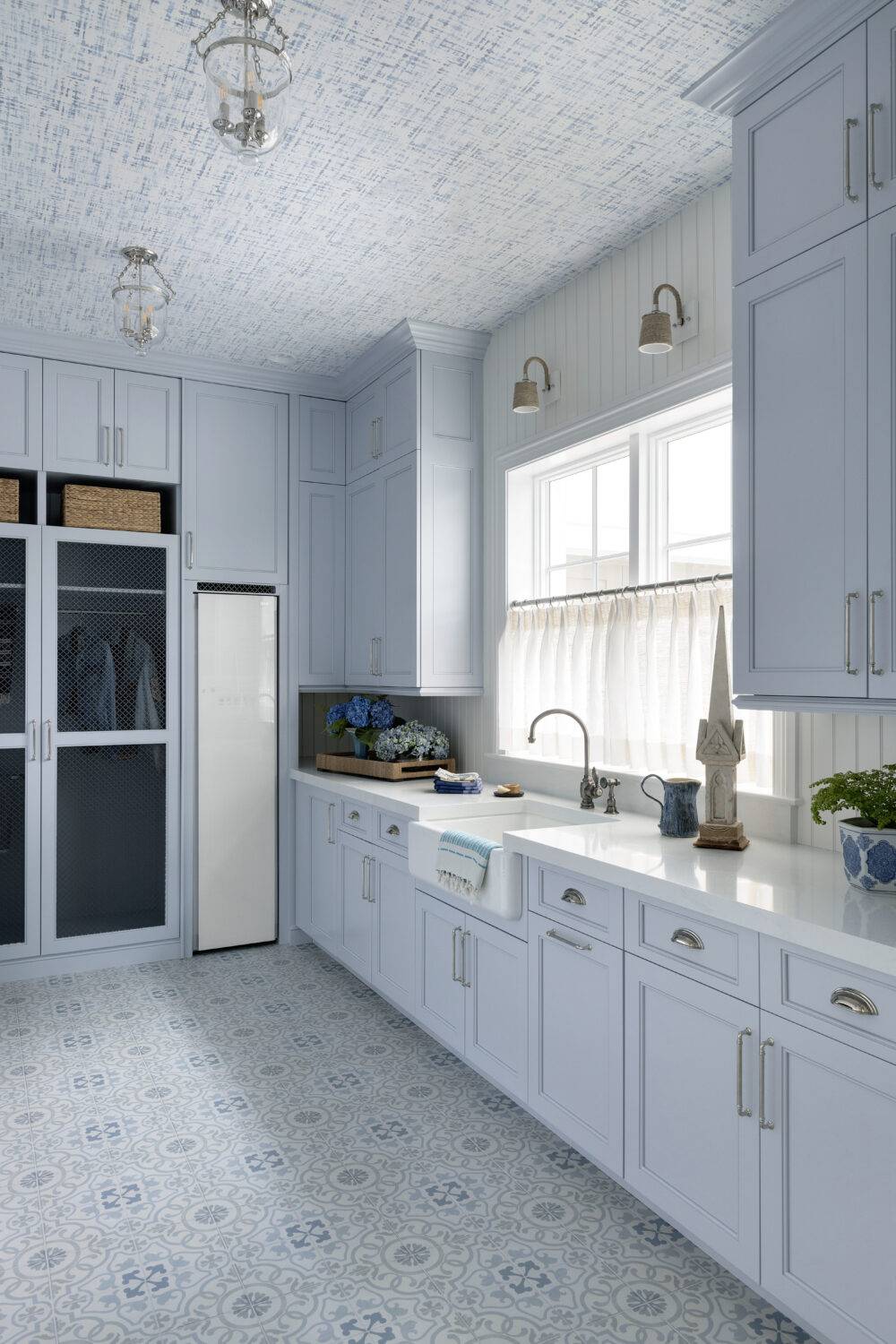 Blue laundry room with blue and grey patterned tile floor. 